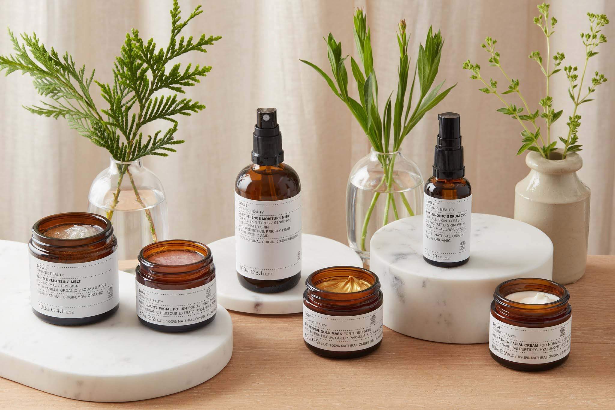 A curated edit of natural, organic skincare in amber apothecary glass surrounded by fresh botanicals